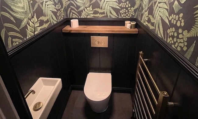 Toilet with wallpaper and wall panelling